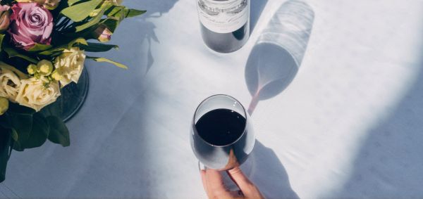 Verres de vin rouge Château Canon et bouquet de fleurs posés sur une table
