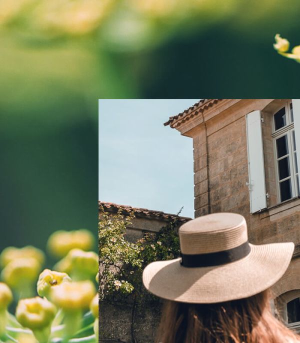 Back view of a woman wearing a hat in front of the Château